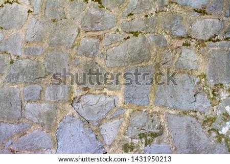 Wall of old stone blocks with moss