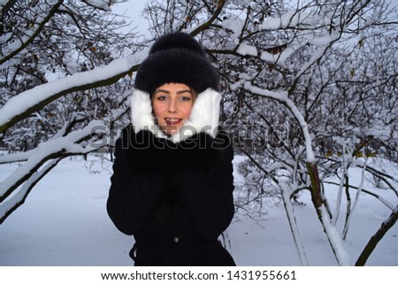 Young girl in hat and white mittens in winter Park
