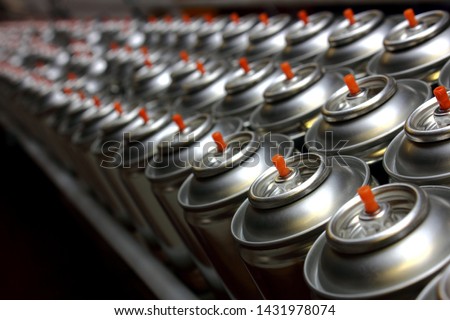 Aerosol cans on production line in factory Royalty-Free Stock Photo #1431978074