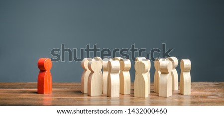 red figurine of a man stands aside from the crowd of people. Asociality, sociopathy. Rejected from society, lonely. Development of leadership and social qualities. Infected, fear and misunderstanding. Royalty-Free Stock Photo #1432000460