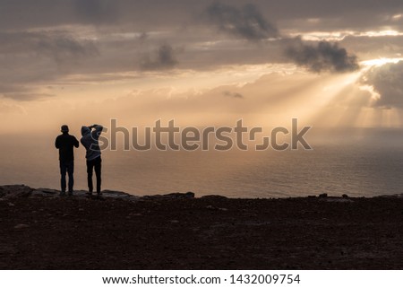 a man takes a picture of the sunset