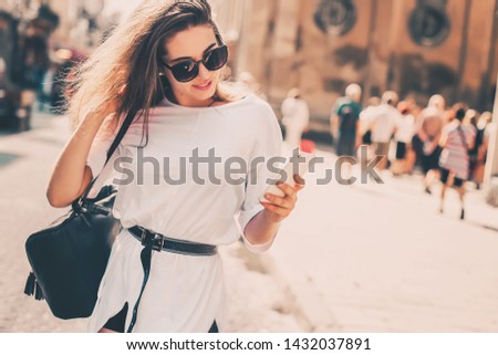 Beautiful woman traveler  using phone walking on the old town street.