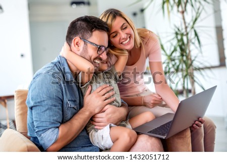 Young family looking at the laptop together at home.