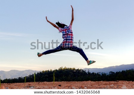 Happy child jumping playing on mountain blue sky background