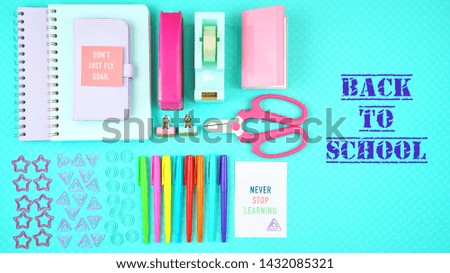 Back to school or workspace colorful stationery on aqua blue background, overhead flat lay with text message.