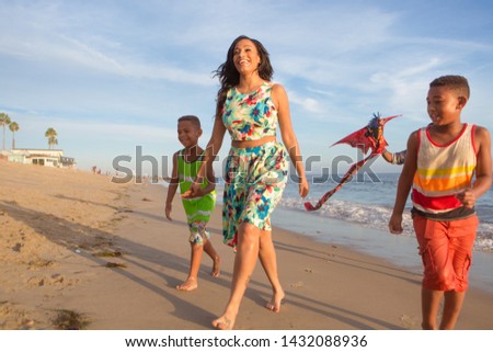 children and their parents  with kite at the beach walking