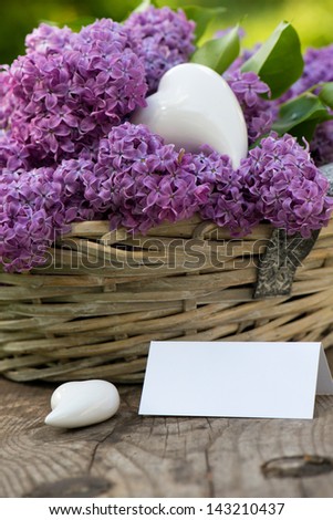 Lilac in a basket on wooden background