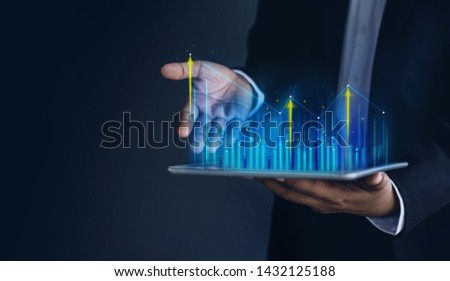 Technology, High Profit, Stock Market, Business Growth, Strategy Planing concept. Businessman in Suit Present Graphs and Charts information on digital tablet
