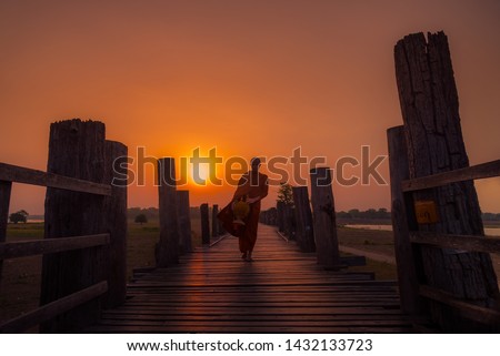 Asian  monk buddha religion Walking alms in early morning for Buddhist
Offer food to monk at U-bein bridge , Myanmar.
