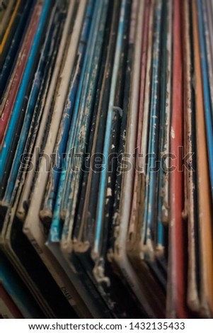 A colorful collection of  antique vinyl records in cases stacked up against each other. Antique collectors, millennial trends, old music technology concepts.