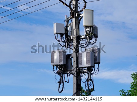 Small Cell 4G, 5G. Macro Base Station or Base Transceiver Station on electricity post. Wireless Communication Antenna Transmitter. Development of communication system in urban area against blue sky. Royalty-Free Stock Photo #1432144115