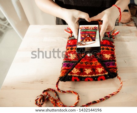 Women taking photo to Bags and products with cell telephone or smartphone digital camera for Post to sell Online on the Internet .