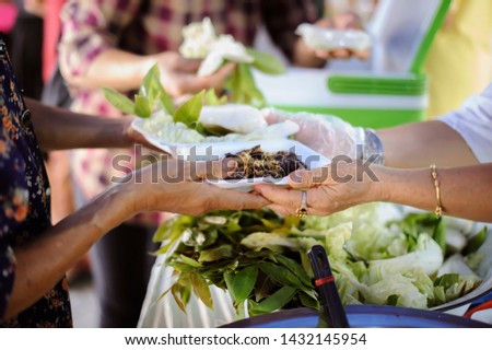 Hand offered to donate food from a rich man Share : The concept of social sharing : Poor people receiving food from donations : Homeless people are helped with food relief, famine relief 