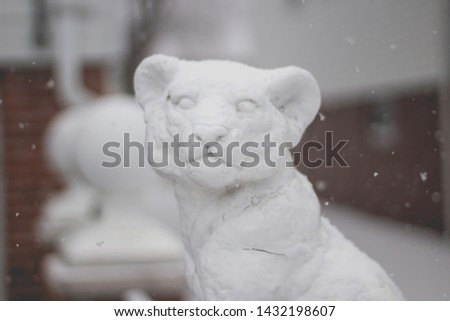 A beautiful lion cub made of snow during winter