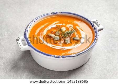 Bowl of tasty sweet potato soup with pumpkin seeds on table