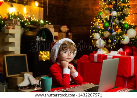 Gifts service. Santa little helper. Smart toddler surfing internet. Little boy santa hat and costume. Boy child with laptop near christmas tree. Buy christmas gifts online. Christmas shopping concept.