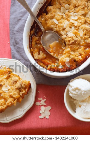 Overhead image of plum cobbler with almond flakes and cream