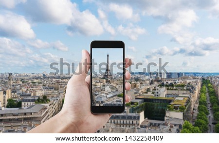 Hand taking photo of Eiffel tower, famous landmark and travel destination in Paris, France by mobile smart phone