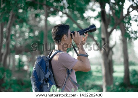 Young photographer holding camera take photo in forest