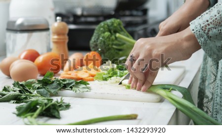 Human hands slicing vegetables in kitchen. Healthy food. Woman preparing vegetables Royalty-Free Stock Photo #1432293920