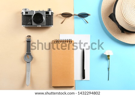 Photo camera, sunglasses, notebook, watch and hat on color background