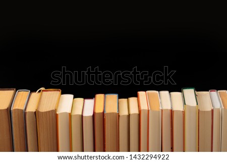Stack of books on a black  background.Education. - Image 