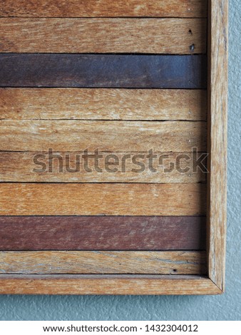 crop closeup on decorative simple timber wood picture frame hanging on the wall for backdrop background use