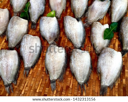 Dried salted snakeskin gourami fish on bamboo basket, of Thailand.