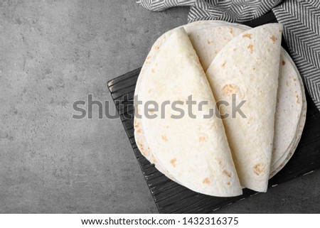 Corn tortillas on grey background, flat lay with space for text. Unleavened bread