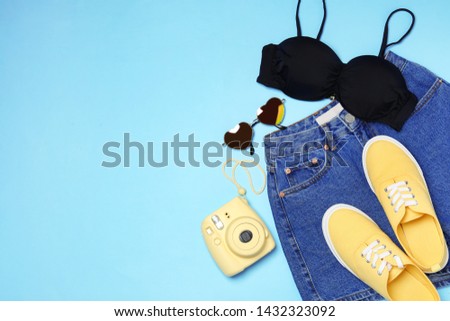 Flat lay composition with stylish bikini on color background, space for text. Beach objects