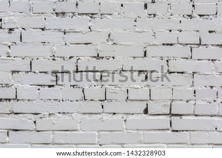 White brick wall smeared with whitewash. The background