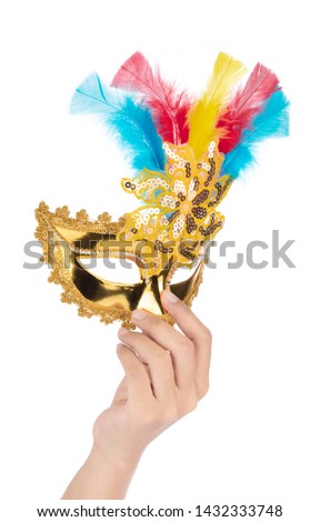 Hand holding Beautiful of gold mask with feather isolated on a white background.