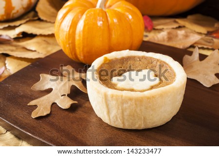 Pumpkin tart surrounded by colorful fall leaves and pumpkins