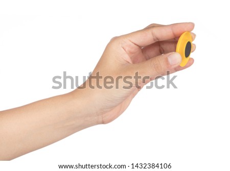 Hand holding Yellow Round Plastic Magnet isolated on white background
