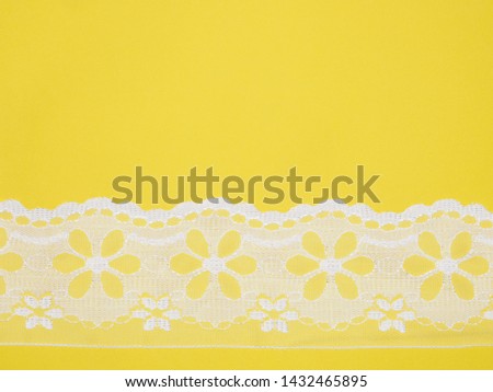 White lace on yellow background. Sewing still life