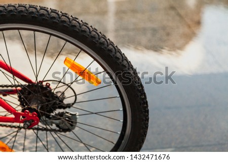 rear wheel of a modern bike with a reflector on a gray blurred background.
