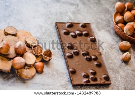 Homemade hazelnut chocolate bar. Nuts and chocolate background. Ingredients for cooking homemade chocolate sweets. Confectionery and sweets concept