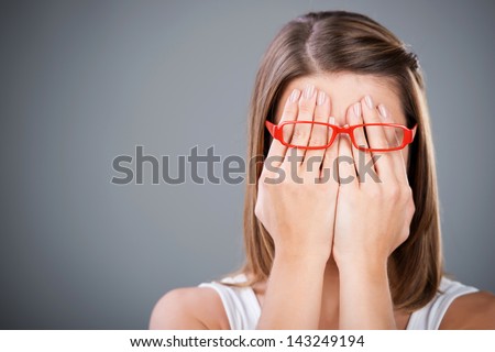 Young brunette woman covering face using her both hands Royalty-Free Stock Photo #143249194