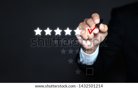 Businessman putting check mark a checkbox on five star rating. Increase rating company or ranking, evaluation and review concepts Royalty-Free Stock Photo #1432501214