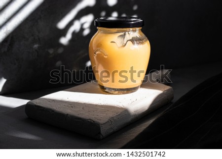 Late afternoon dark mood photo of lemon curd jar
