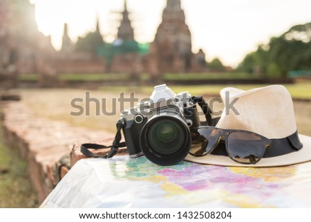 Retro camera on map with hat, sunglass on Ayutthaya Historical National Park Background.