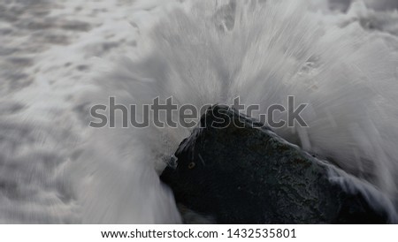 Waves crashing on a rock in black and white. Power of the sea