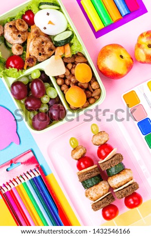 School supplies, colorful stationery, backpack and lunchbox with funny food for kids . Back to school concept lay out