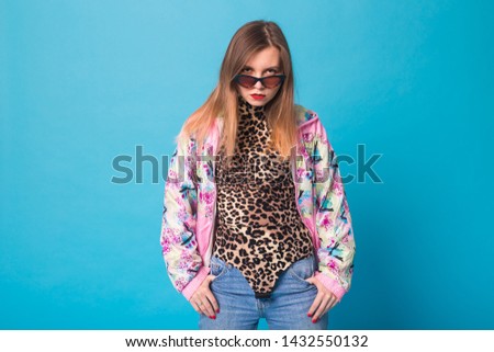 Vintage fashion look concept - pretty young woman wearing a retro jacket and leopard body on blue background
