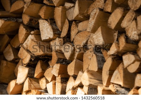 Stack of firewood prepared for winter outdoors. Wooden pile of log tree. Raw material for fireplace. 