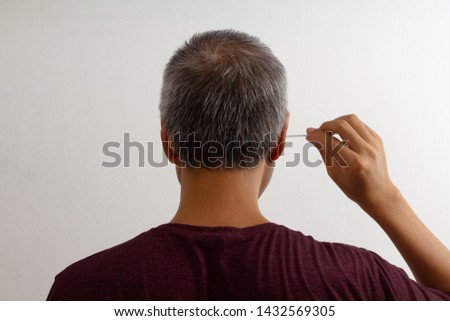Men use cotton bud to clean ears isolated on white background.