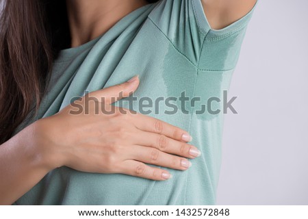 Close-up asian woman with hyperhidrosis sweating. Young asia woman with sweat stain on her clothes against grey background. Healthcare concept. Royalty-Free Stock Photo #1432572848