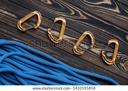View from the top. Isolated photo of climbing equipment. Part of carabiner lying on the wooden table.
