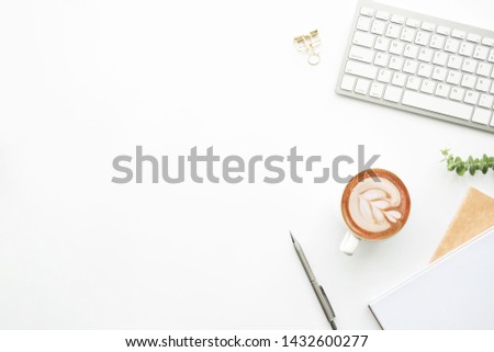 Minimal modern office desk table with computer keyboard, cup of coffee and supplies. Top view with copy space, flat lay.