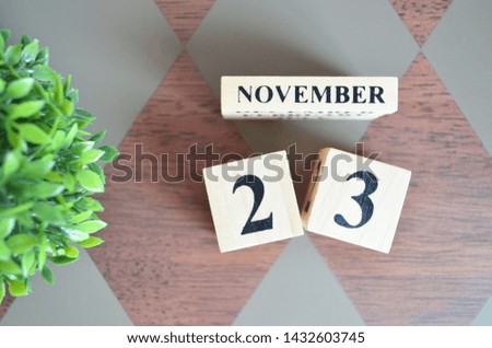 Date of November month with leaf on diamond pattern table for background.